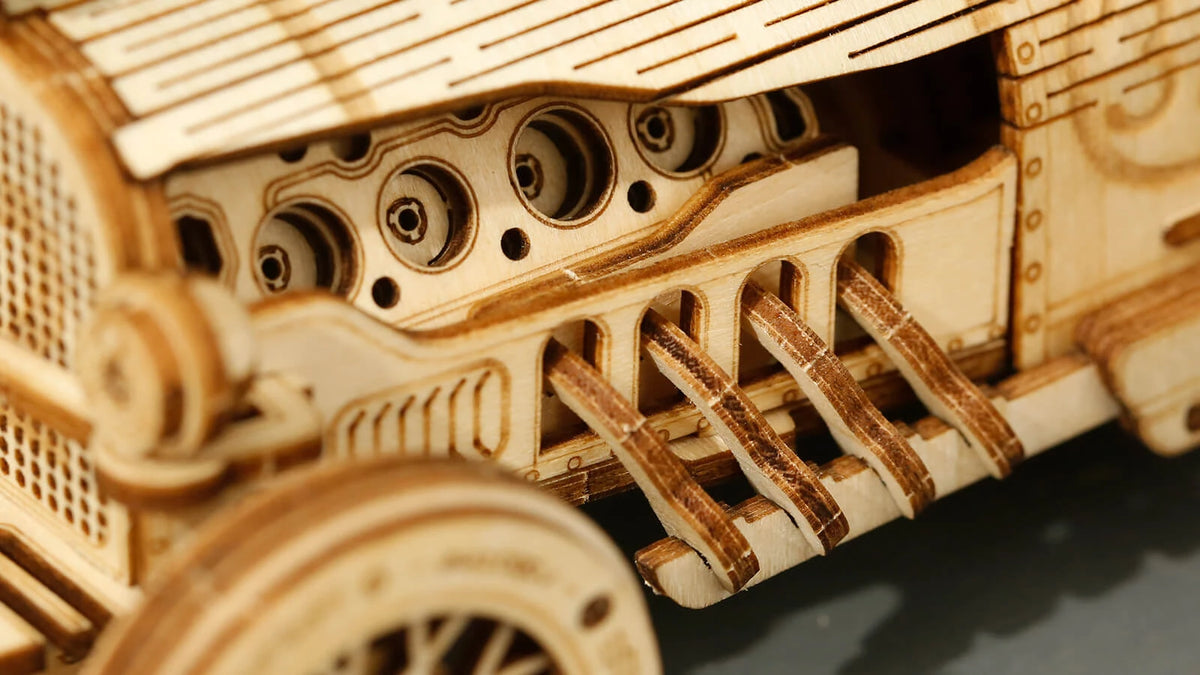 Gros plan du moteur V8 et des tuyaux d'échappement en bois de la maquette L'Héritage Automobile