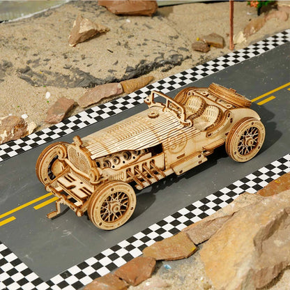 Maquette en bois L'Héritage Automobile posée sur une piste de course à damier, vue plongeante