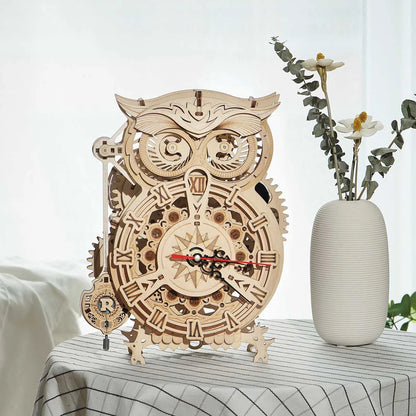 Horloge hibou en bois posée sur une table à côté d'un vase blanc