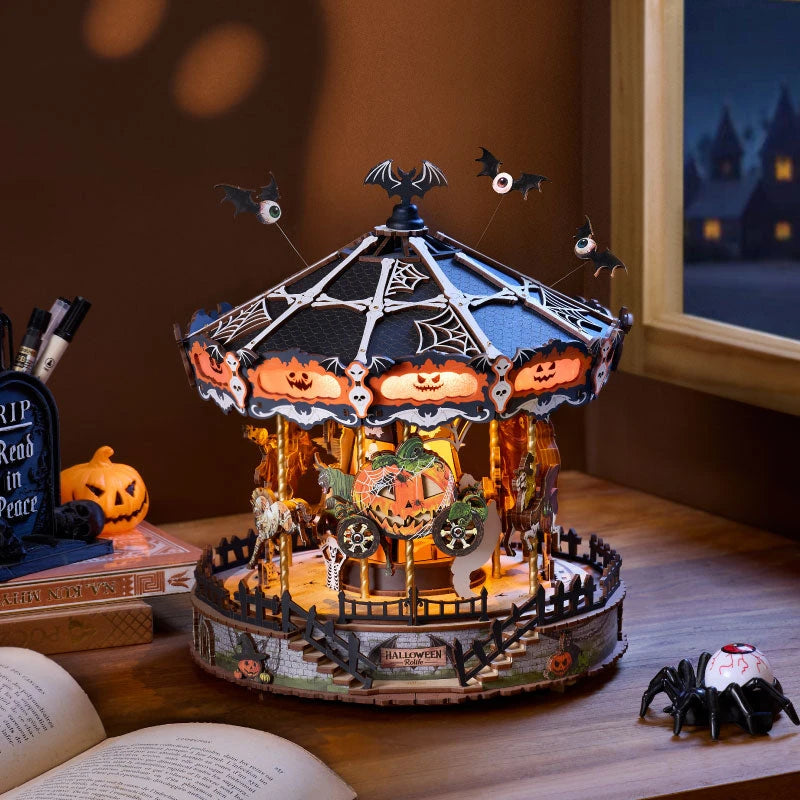 Manège Halloween Phantom Waltz allumé sur un bureau au crépuscule, près d'un livre