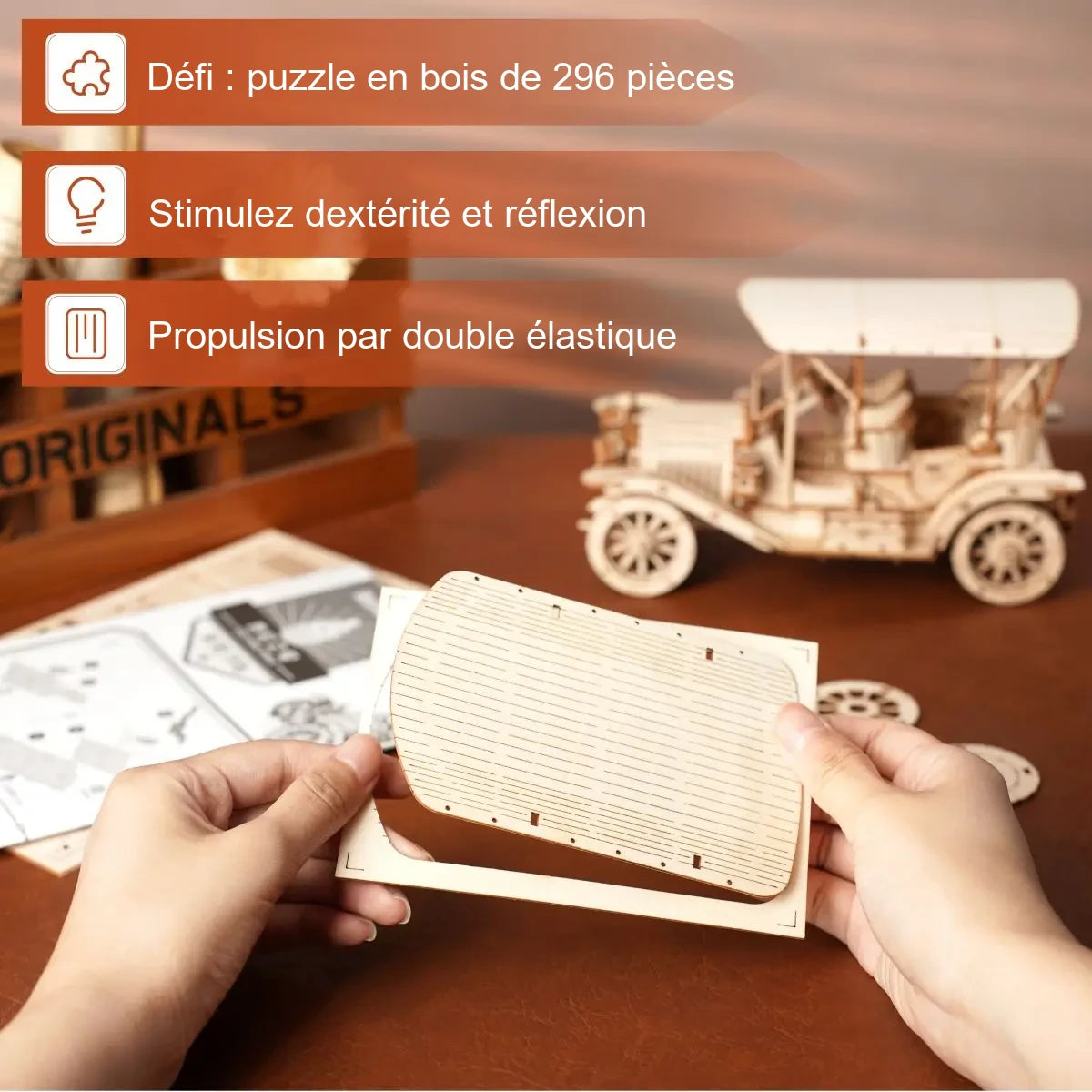 Mains tenant la pièce de toit du Roadster Rétro pendant le montage, maquette finie en arrière-plan