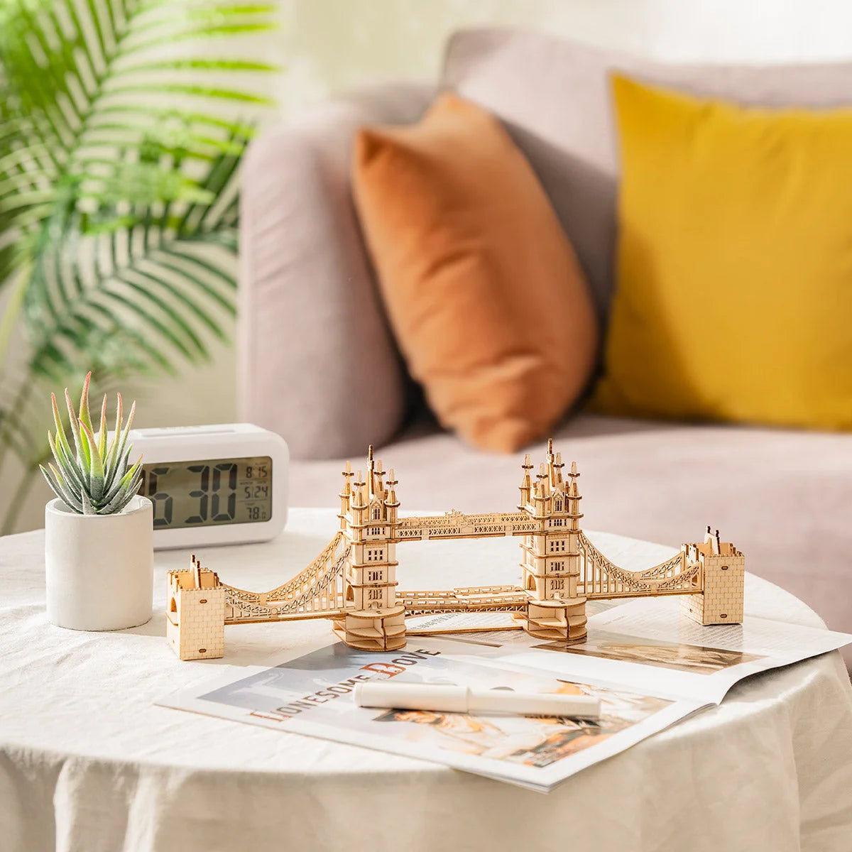 Tower Bridge en bois monté posé sur une table de salon près d'un réveil