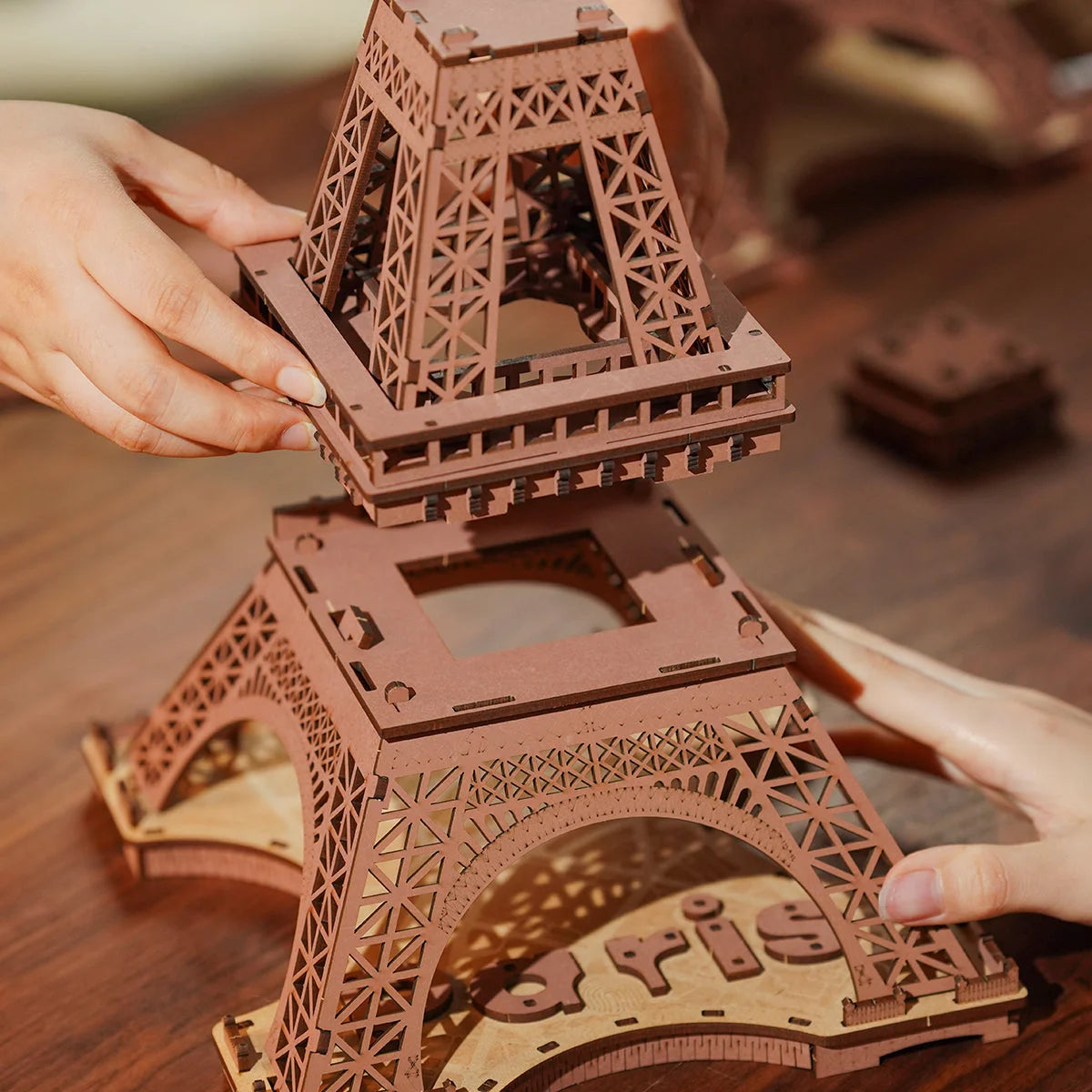 Mains assemblant l'étage intermédiaire de la Tour Eiffel en bois